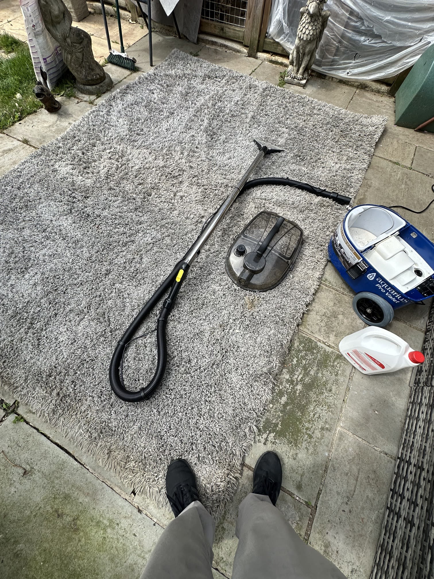 Carpet cleaning wand and hose working on a fitted carpet